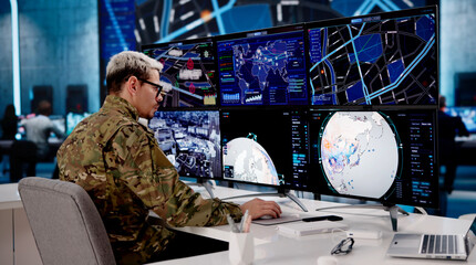 Army Officer Overseeing Numerous Computer Displays
