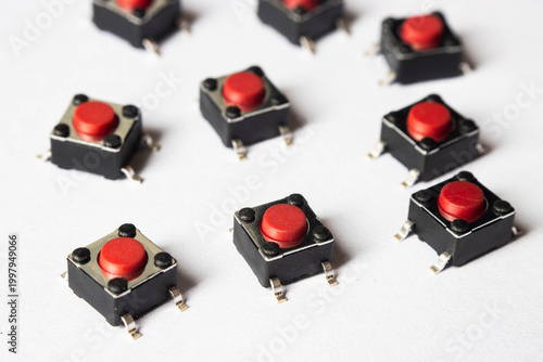 фотографія Red tactile push buttons on white background arranged in pattern