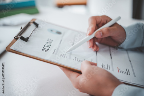 People are reviewing job applications before filling out their resume on the job application form in order to apply for a job at a company.