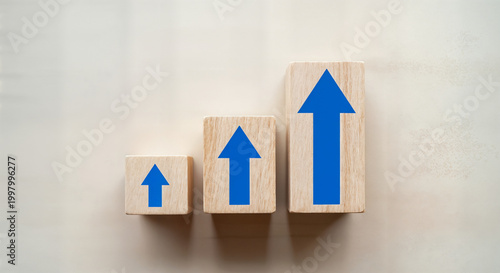 3d blue growth arrows on wooden blocks