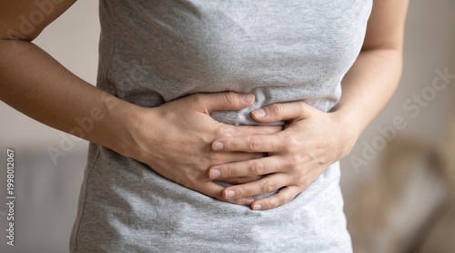 Billede på lærred Close up of young woman holding belly suffering from severe stomach pain