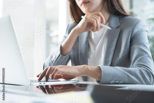 Businesswoman focus working at office using laptop with digital tablet on desk, corporate business concept