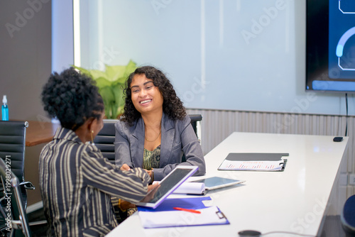 Two businesswoman sitting in meeting room and talking together for relax from serious agenda in meeting session.