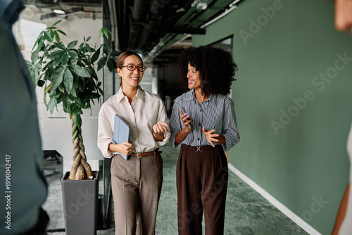 Bild auf Leinwand Portrait of two young business woman having a meeting or presentation and seminar standing in the office