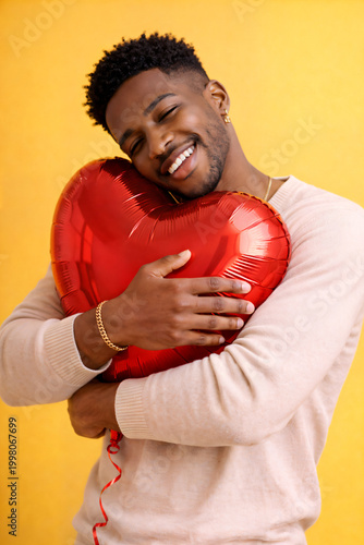 Smiling Person with Heart Balloon on Yellow Background