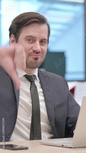 Businessman Showing Thumbs Down Sign While using Laptop in Office, Vertical Video