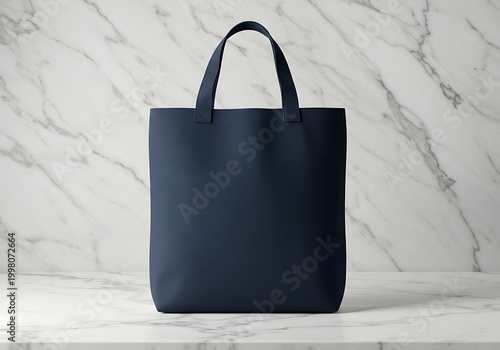 Navy tote bag on white marble surface studio shot copy space