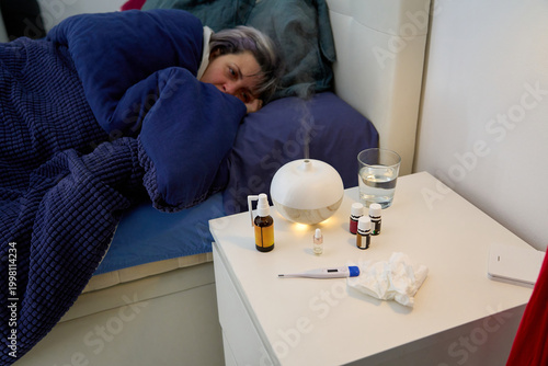 Tableau sur toile Sick woman resting in bed with humidifier aroma diffusing
