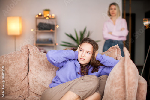 Bild auf Leinwand Close up offended girl in front and woman behind avoid to talk after quarrel at home, upset teen daughter and middle aged mum argument, two generation conflict concept