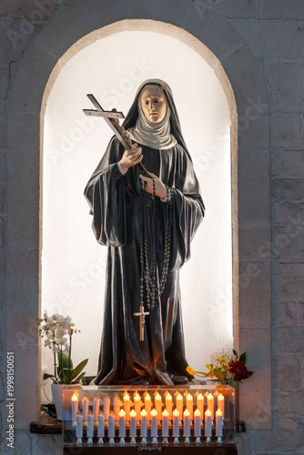 Canvas Print Religious statue of a Catholic nun holding a crucifix and rosary inside a church in Alberobello, Puglia, Italy