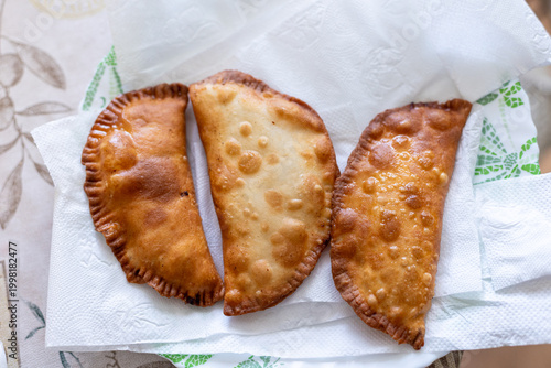 Chebureks. Oil-fried pies filled with minced meat and onions with sauces. On a white background, isolated. 
