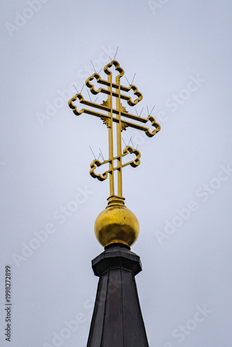 Photography Golden Orthodox cross against clean sky background symbolizing Christian faith r