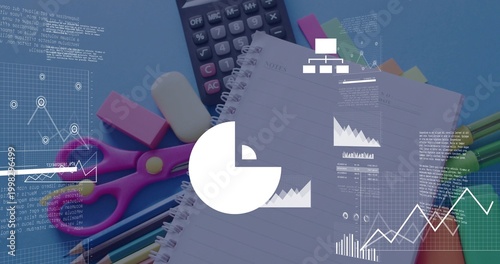 Showing spiral notebook on blue desk with calculator, pink scissors, pencils, pens, digital charts