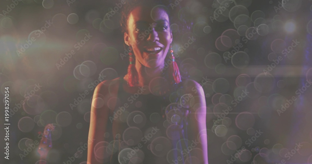 Obraz premium Singing singer center stage, wearing sleeveless top, red tassel earrings, mic, guitar, bokeh haze