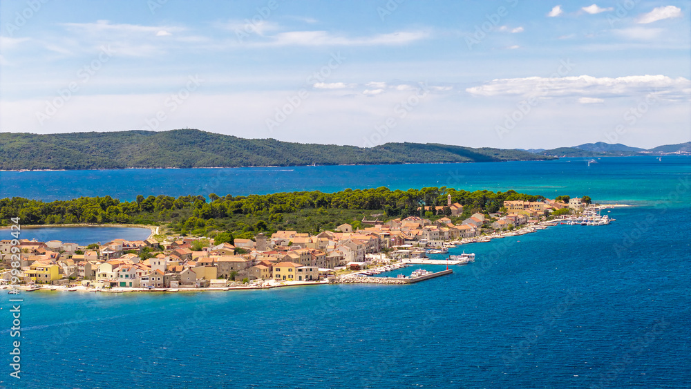 Fototapeta premium Aerial view of the picturesque island of Krapanj in Croatia with traditional stone houses and turquoise Adriatic Sea water on a sunny day