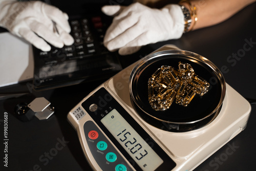 Photos Jeweler weighs rings on a precision scale to determine their exact value