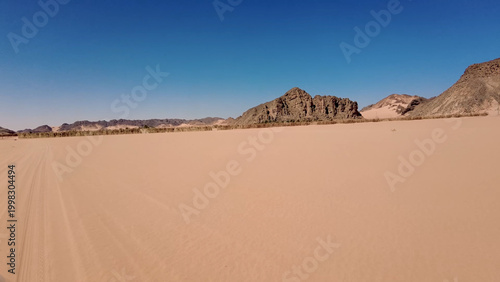 A trip to Sahara desert in Algeria. Beautiful 
african travel photo. Sandy landscapes, mountains, rocks,
dunes, and nature. Summer vacation in arab country.