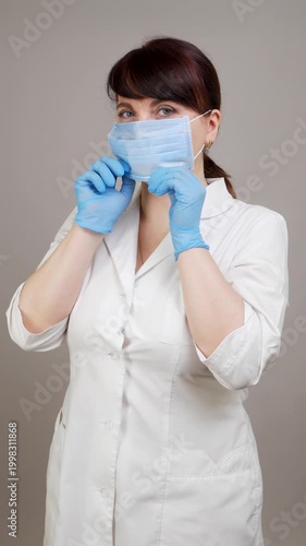 A healthcare worker in a white coat demonstrates the correct use of a mask, first holding it in her hands, then putting it on, and finally adjusting it to ensure it fits securely, in a neutral setting