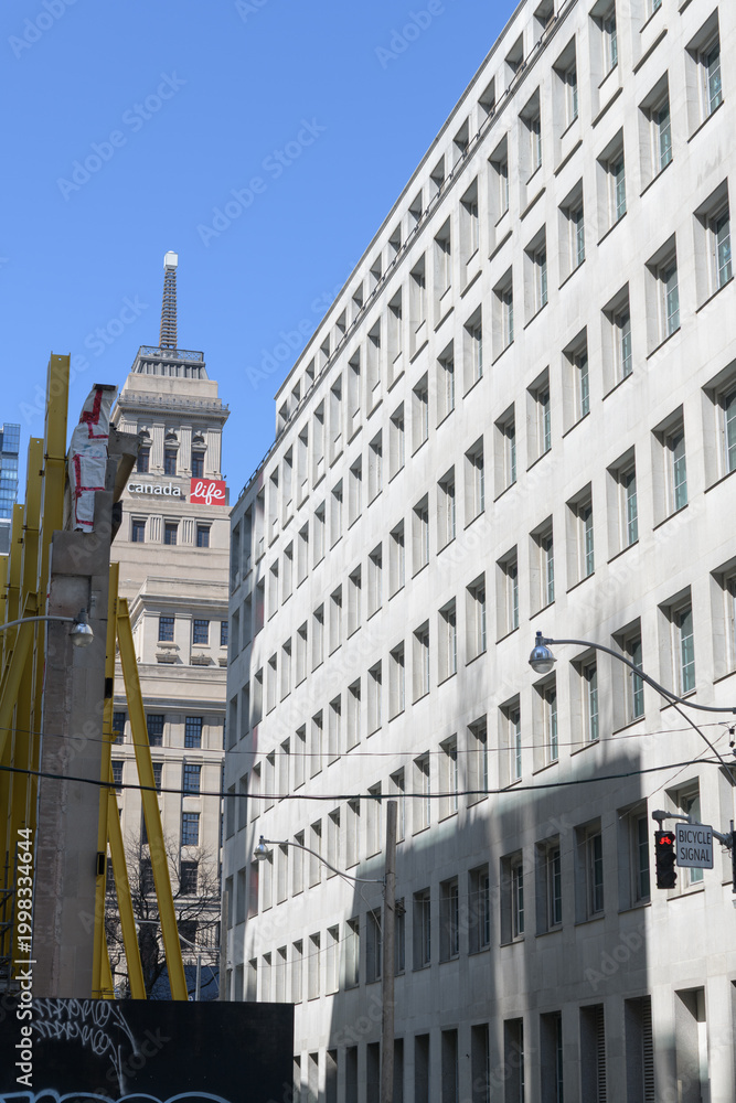 Fototapeta premium looking north on Simcoe St (south of Queen St W) to Canada Life Building and sign location of a future Ontario Line station, Toronto