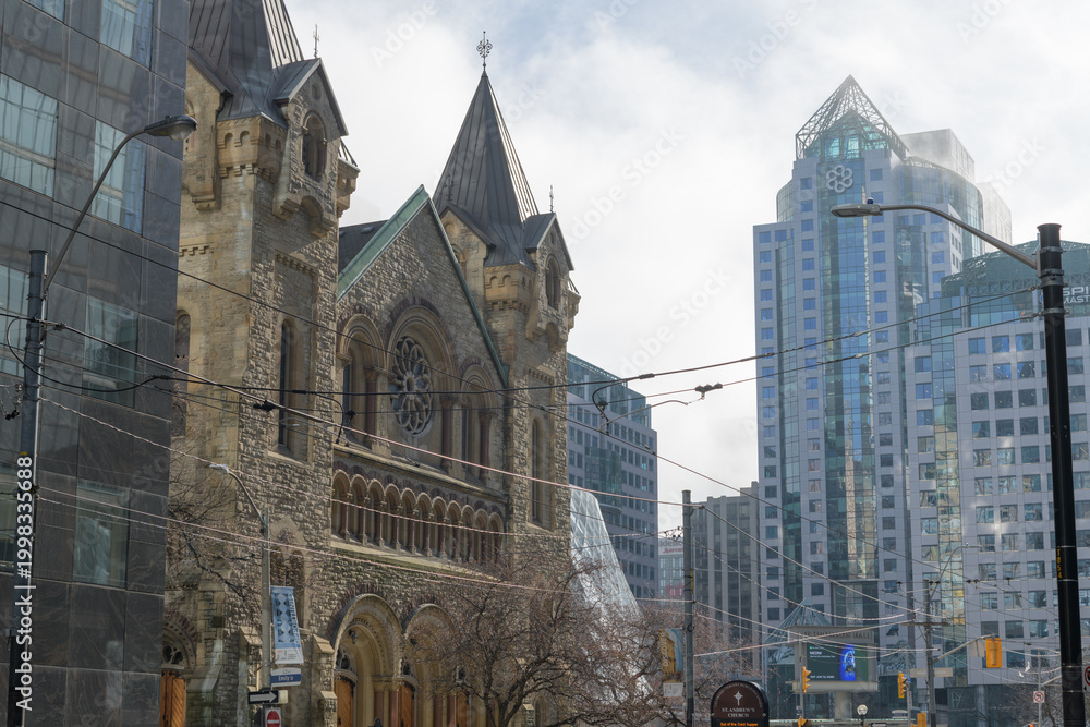 Fototapeta premium looking southwest on King St W near Simcoe St to historic St. Andrew's Presbyterian Church and modern office buildings, Toronto