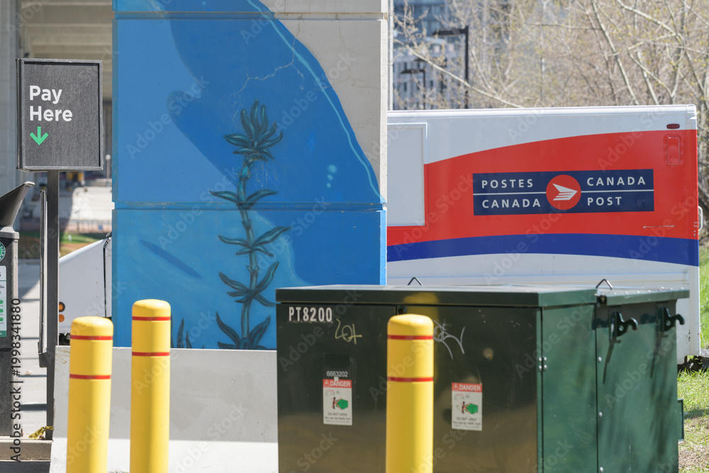 Fototapeta premium City of Toronto municipal parking space with defocused Canada Post delivery truck under the elevated Gardiner Expressway, known as The Bentway, Toronto