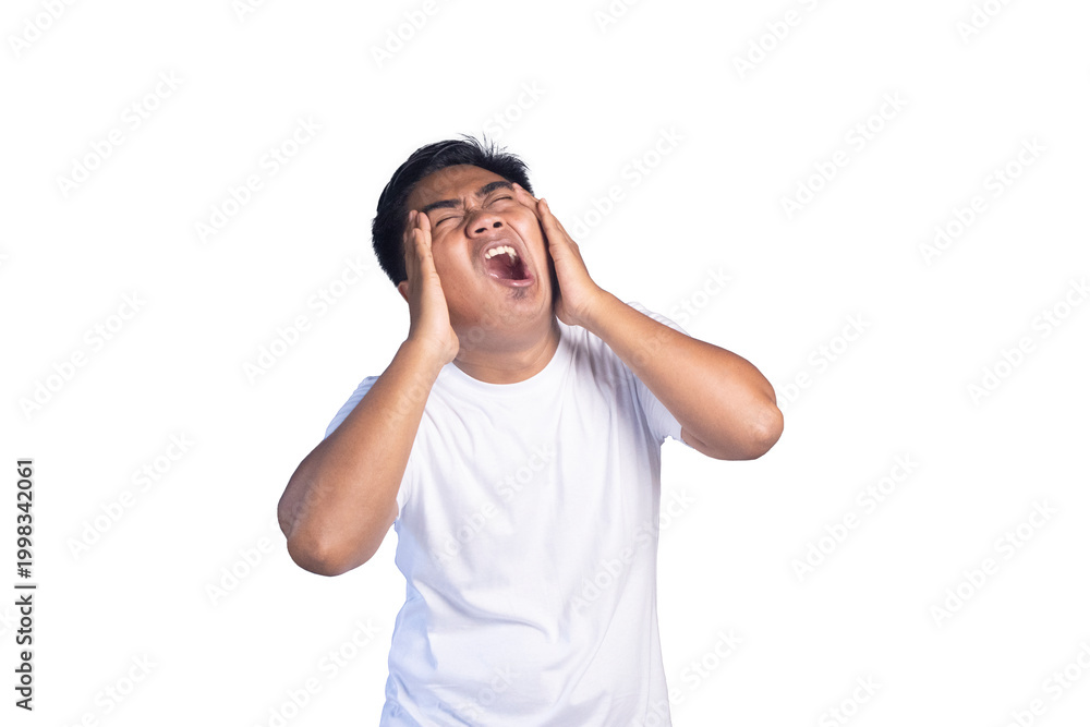 Fototapeta premium Stressed young Asian man in white t-shirt holding his head and screaming in frustration against white background.