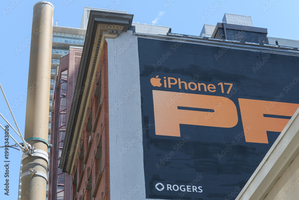 Obraz premium mural advertising for cell phone on exterior wall of the historic Warwick Bros. & Rutter Ltd building 401-409 King St W at Spadina Av, Toronto