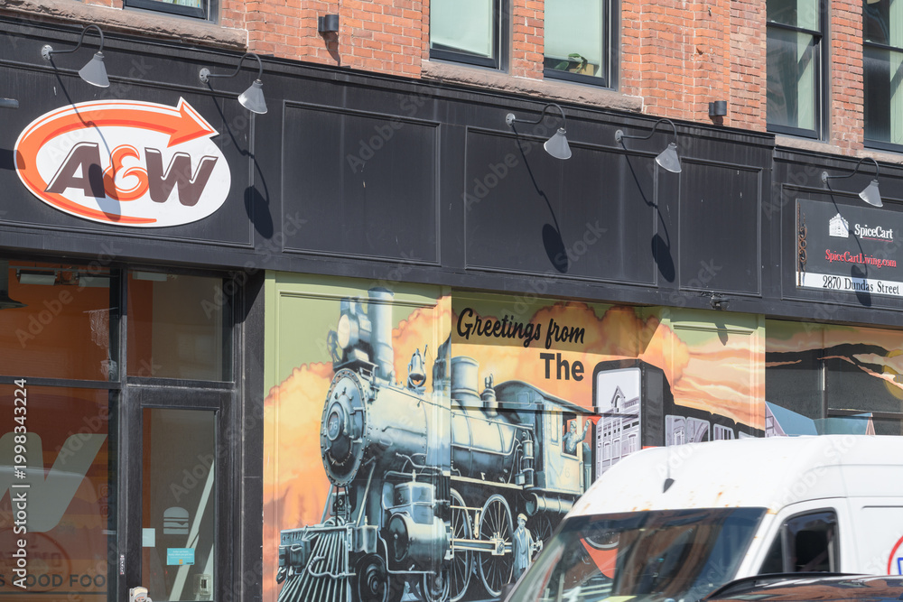 Obraz premium exterior building and sign of A&W Canada, a hamburger restaurant chain, located here at 2858 Dundas St W (northwest corner) in historic Campbell Block, The Junction, Toronto