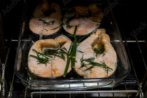 Salmon steaks baked in the oven. Salmon walls with herbs on a glass baking sheet. In the oven.