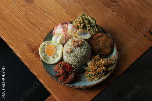 Konstfotografi Nasi Campur Bali, a typical dish from the Bali region of Indonesia, consists of rice and side dishes such as spicy chicken, sautéed vegetables, fried egg, fried food, and crackers