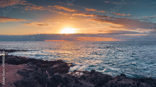 Golden hour light over rocky ocean coast in tropical island Tenerife Spain