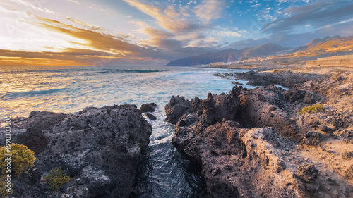 Foto Golden hour light over rocky ocean coast in tropical island Tenerife Spain