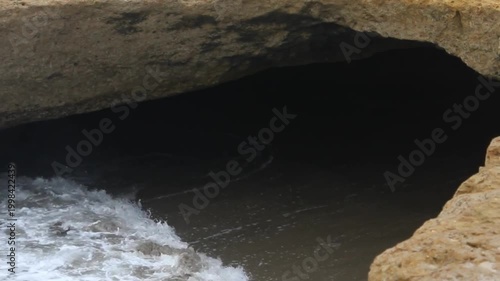 Rocky Beach Cave with Ocean Water Flowing Inside – Waves Entering Sea Cave at Coastal Shore, Natural Seaside Landscape, Dramatic Ocean Rock Formation Stock Footage 4K Cinematic
