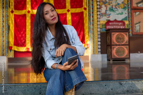 Seated woman looking away while holding mobile phone