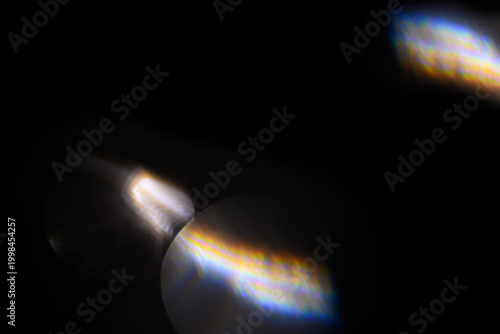 Iridescent light leaks on black background for overlay use. Optical prism flare creating rainbow glow effect for creative photo manipulation
