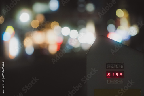 Fotografia 夜の都会の街角で美しく輝く玉ボケを背景にしたパーキングメーター