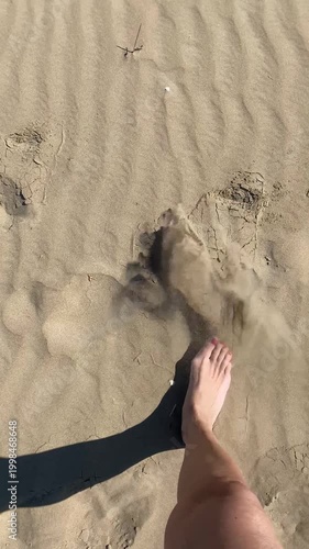 Piedi con smalto rosa sulla sabbia