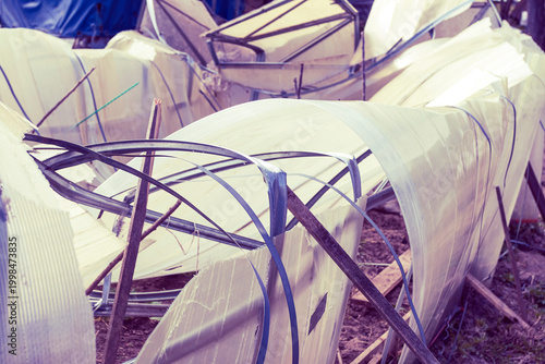 Fotografía Greenhouse structure in disrepair with broken panels and scattered materials nea