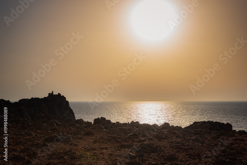 Sunset over the coast, rock formations, big ball sunshine