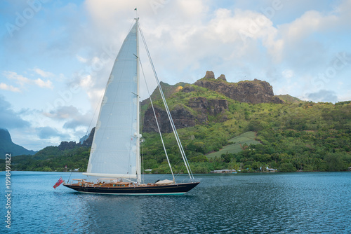 Billede på lærred Classic Sailing Superyacht with mainsail hoisted leaving Cook's Bay, in the paci