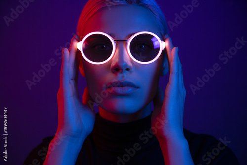 Woman wearing futuristic neon glowing sunglasses
