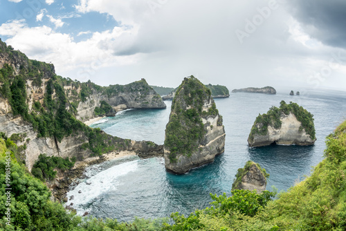 Slika na platnu Tall Bali cliffs and white sand beaches with offshore islands under blue sky and