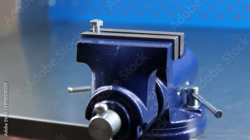 Metal vise fixed on a metal table.