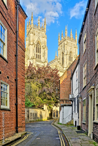 View through the Old Town streets of York, England with brick houses and the the beautiful facade of York Minster