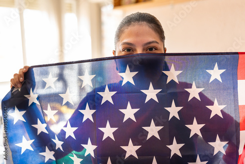 Latin American woman holding a USA flag, showing patriotism and support for country
