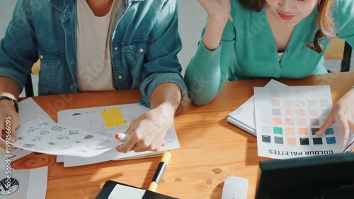 Foto Close up of smart business team hands looking at color palette at table while throw paper in the air
