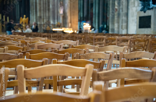 Tableau sur toile On a spring day in France, inside the Bordeaux Cathedral, wooden chairs for the parishioners are arranged in rows, creating a pattern