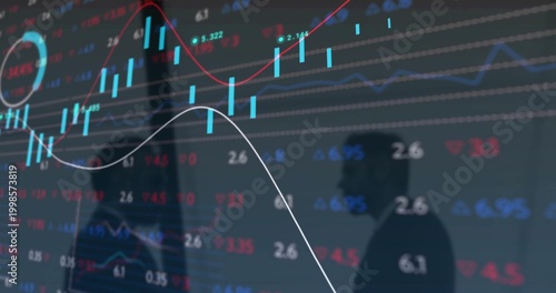 Showing glass screen with candlesticks, tickers, line graphs in office with two colleagues in suits