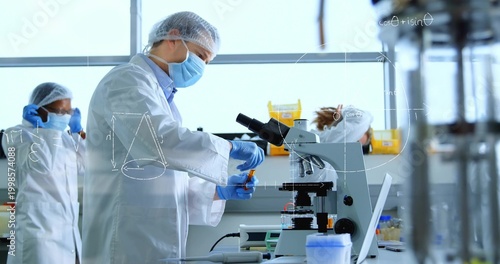 Handling scientist preparing samples at lab bench, wearing white lab coat, using microscope