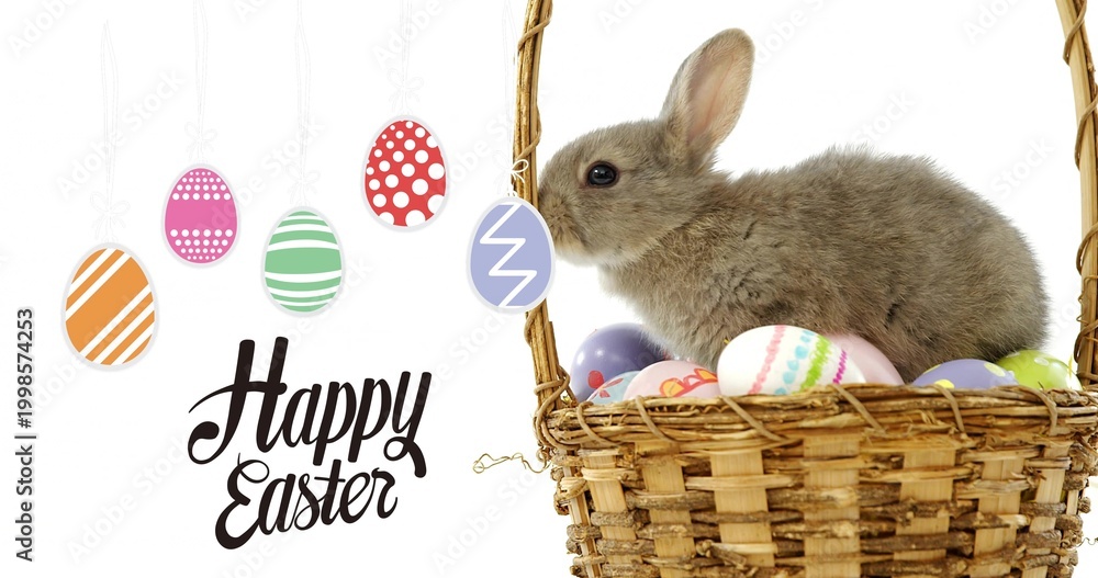 Naklejka premium Sitting brown rabbit nesting eggs in basket at studio, ornaments, Happy Easter text, copy space
